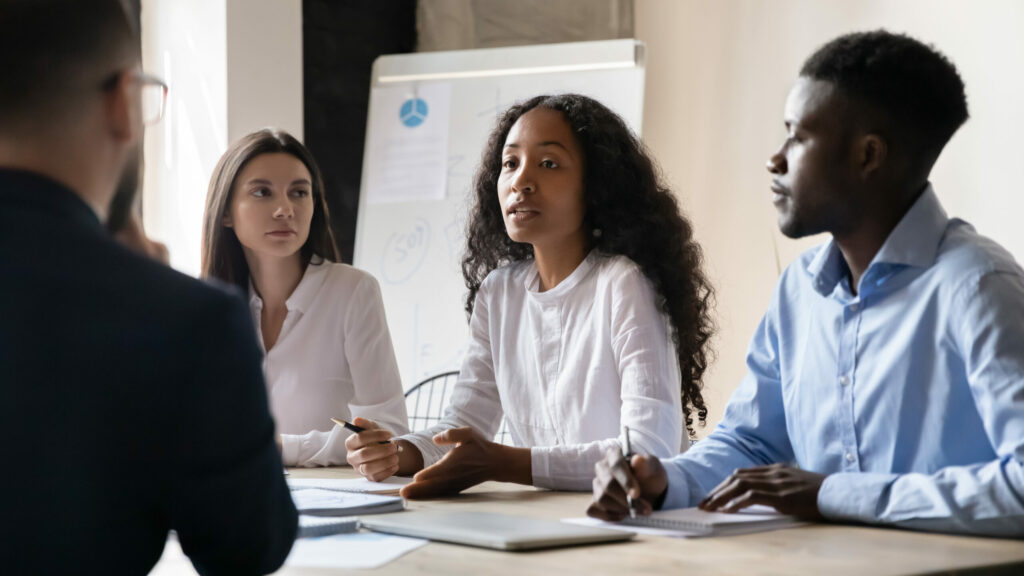 Group of four individuals discussing business