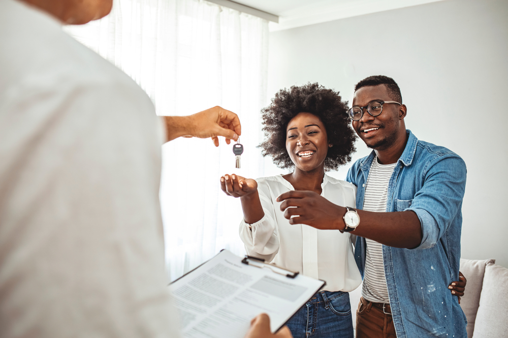 A couple being handed a key to their new home