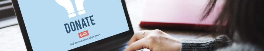 A woman working on a laptop with a Donate image on screen