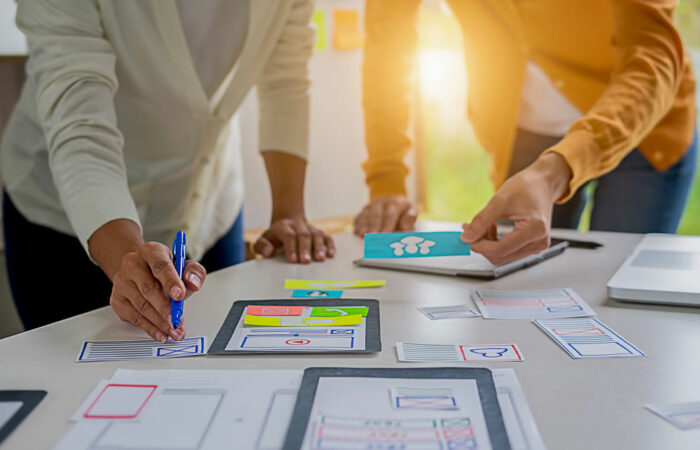 Two people working over diagrams and papers