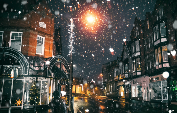 Snowing night outside a corner store