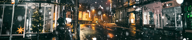 Snowing night outside a corner store